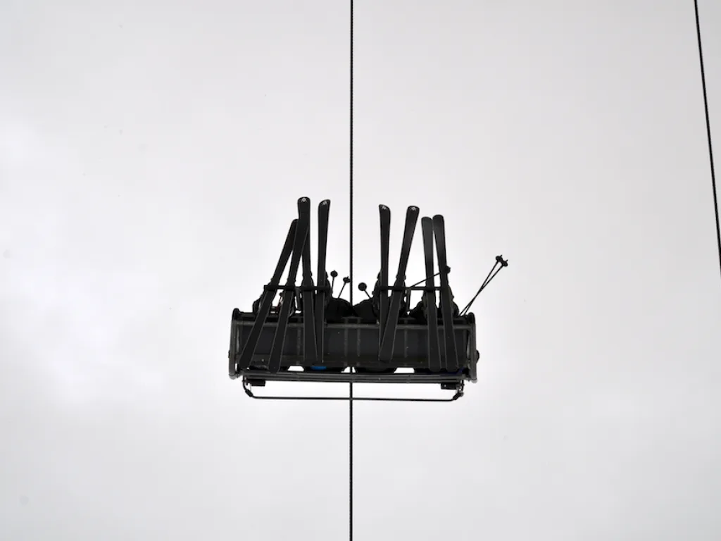Sessellift mit Skiern von unten gegen den Himmel.